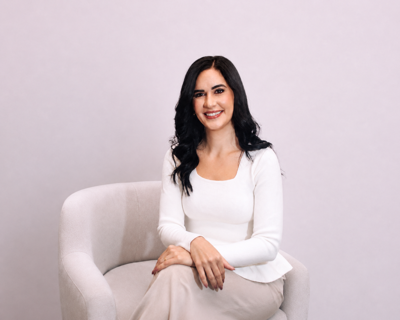 Dra. Bárbara Cássia em poltrona clara