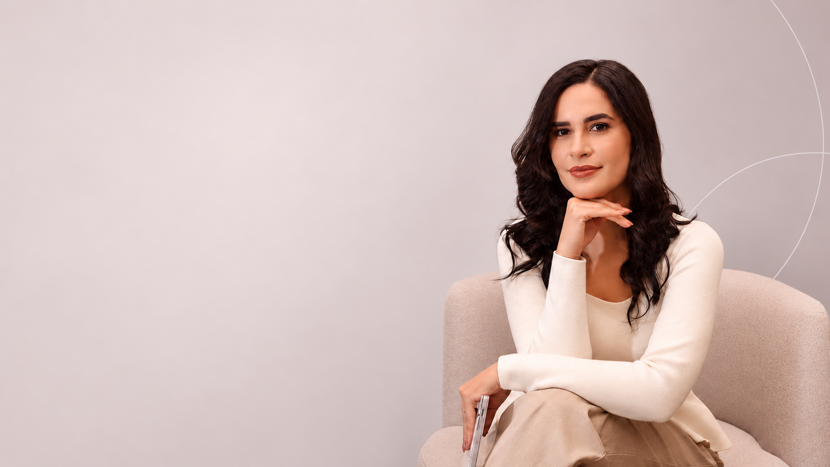 Dra. Bárbara Cássia sentada em poltrona clara